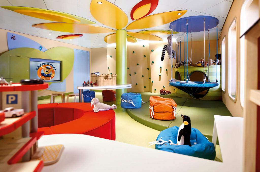 Bunter Kinderspielbereich auf der MS Europa 2 mit Kletterwand, Schaukeln und Sitzsäcken im Käpt'n-Knopf-Design
