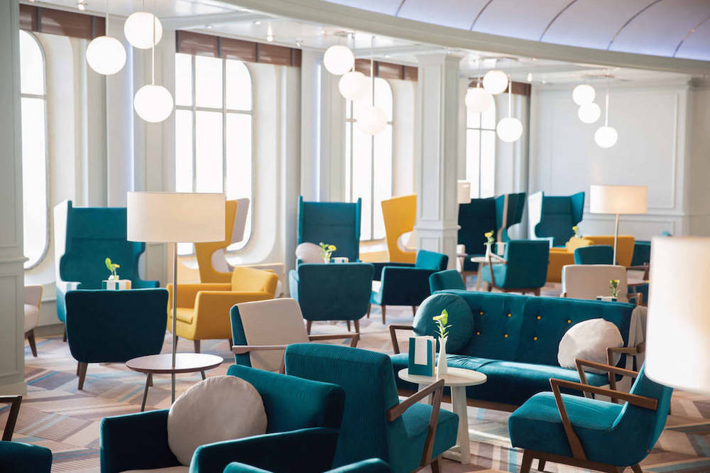 Bar Gatsby's auf der MS Europa mit Art-Déco-Interieur, teal-farbenen Samtsesseln, Bogenfenstern und goldenen Kugelleuchten