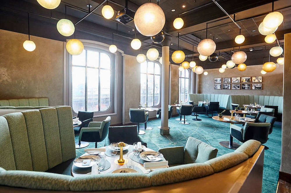Lounge The Globe auf der MS Europa mit grünen Samtsofas, schwebenden Kugelleuchten und großen Bogenfenstern