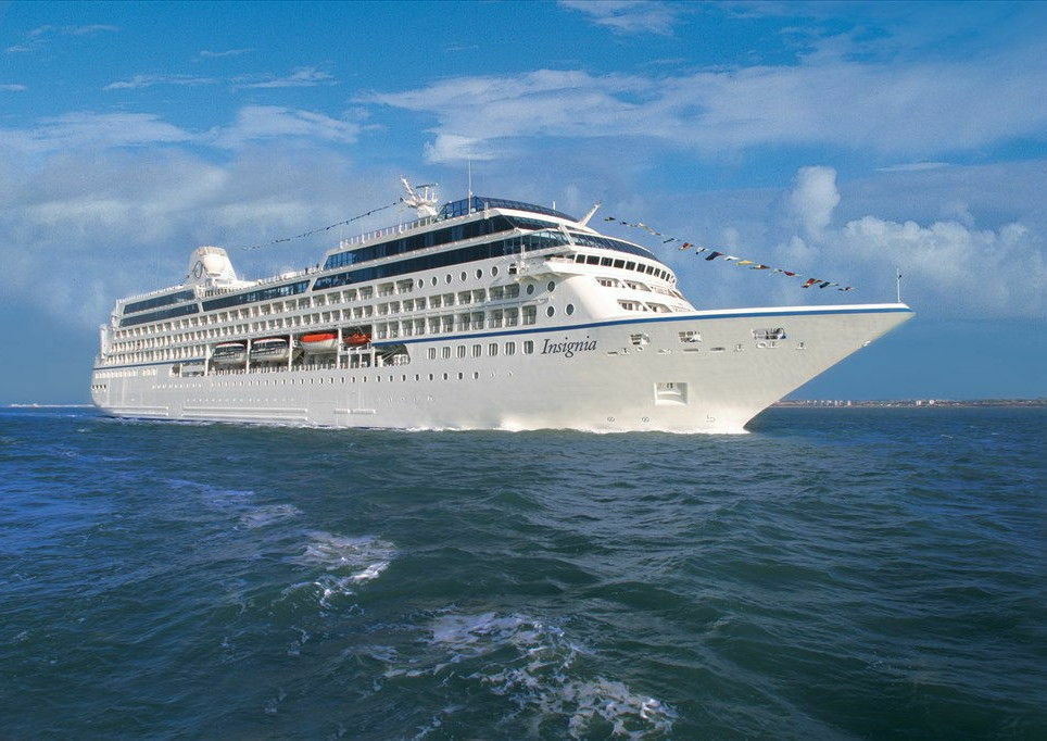 MS Insignia mit festlichen Flaggen auf ruhigem Meer in Seitenansicht, klassisches Luxuskreuzfahrtschiff.