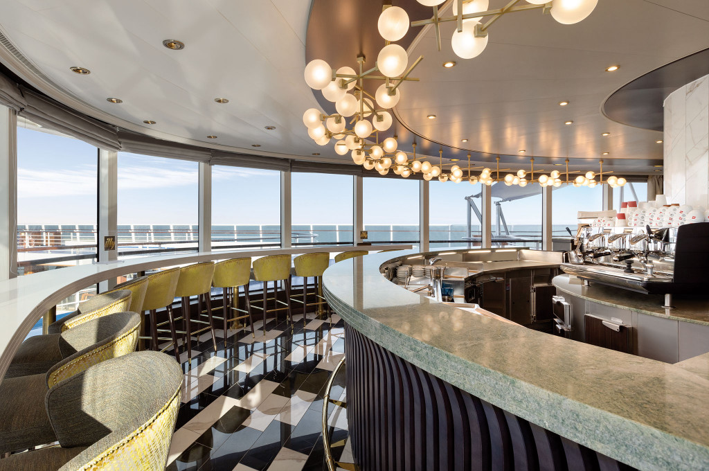 Moderne Café-Bar mit Barhockern, Panoramafenstern mit Meerblick und Designleuchten an Bord eines Hochseekreuzfahrtschiffes.