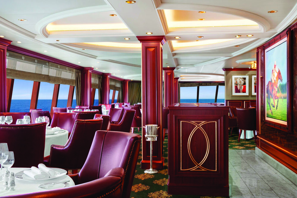 Steakhouse-Restaurant mit burgunderroten Ledersesseln, Panoramafenstern mit Meerblick und Pologemälden an der Wand
