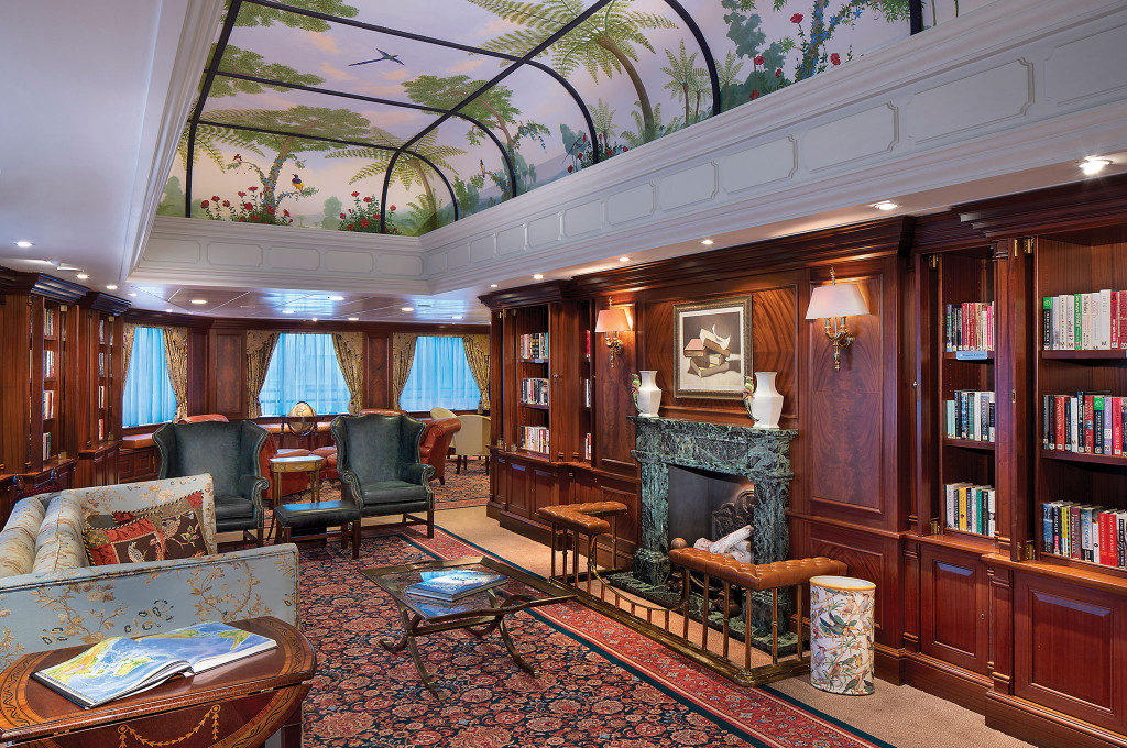 Klassische Bibliothek mit Kamin, Bücherregalen und bemalter Decke auf der Ms Nautica.