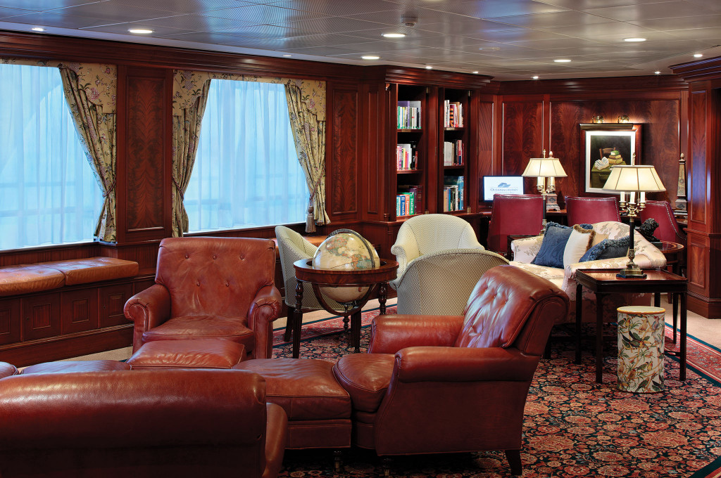 Bibliothek mit Ledersesseln, Globus und Bücherregalen auf der Ms Nautica.