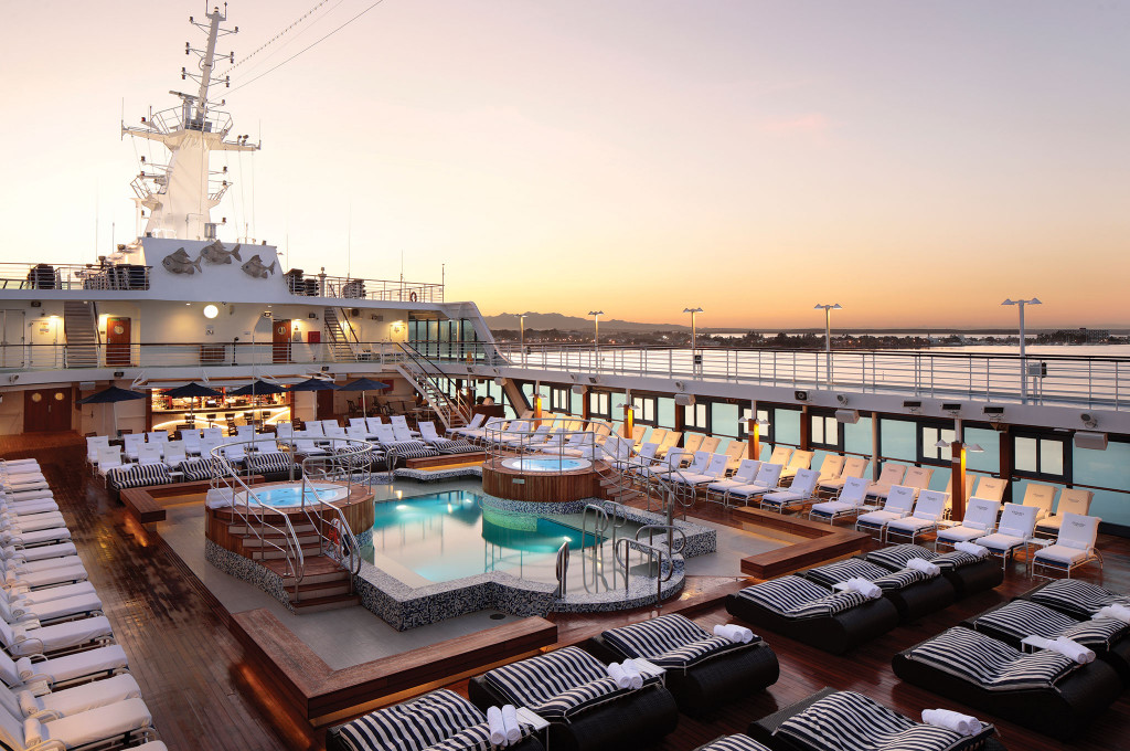 Pooldeck mit Whirlpools, Liegen und Blick auf Hafen bei Sonnenuntergang auf der Ms Nautica.