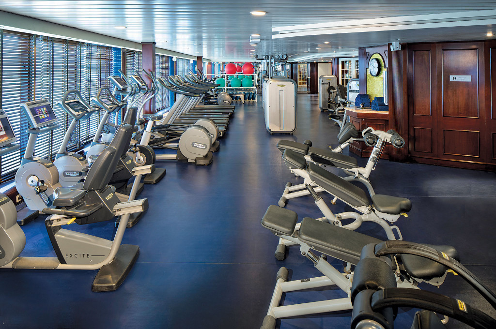 Fitnessstudio mit Laufbändern, Ergometern und Kraftgeräten an Bord eines Hochseekreuzfahrtschiffes.