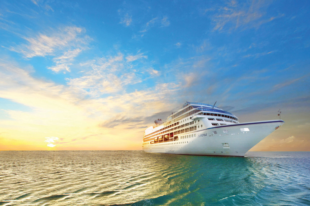 Hochseekreuzfahrtschiff fährt bei Sonnenuntergang über ruhiges Meer unter farbenprächtigem Abendhimmel.