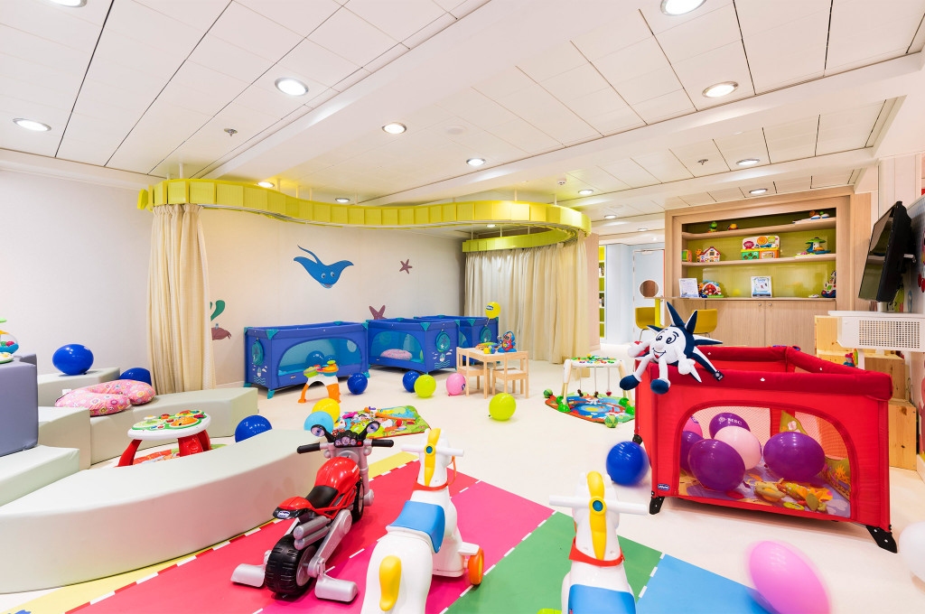 Bunter Babyclub mit Rutschfahrzeugen, Spielmatten und Krippen für Kleinkinder an Bord