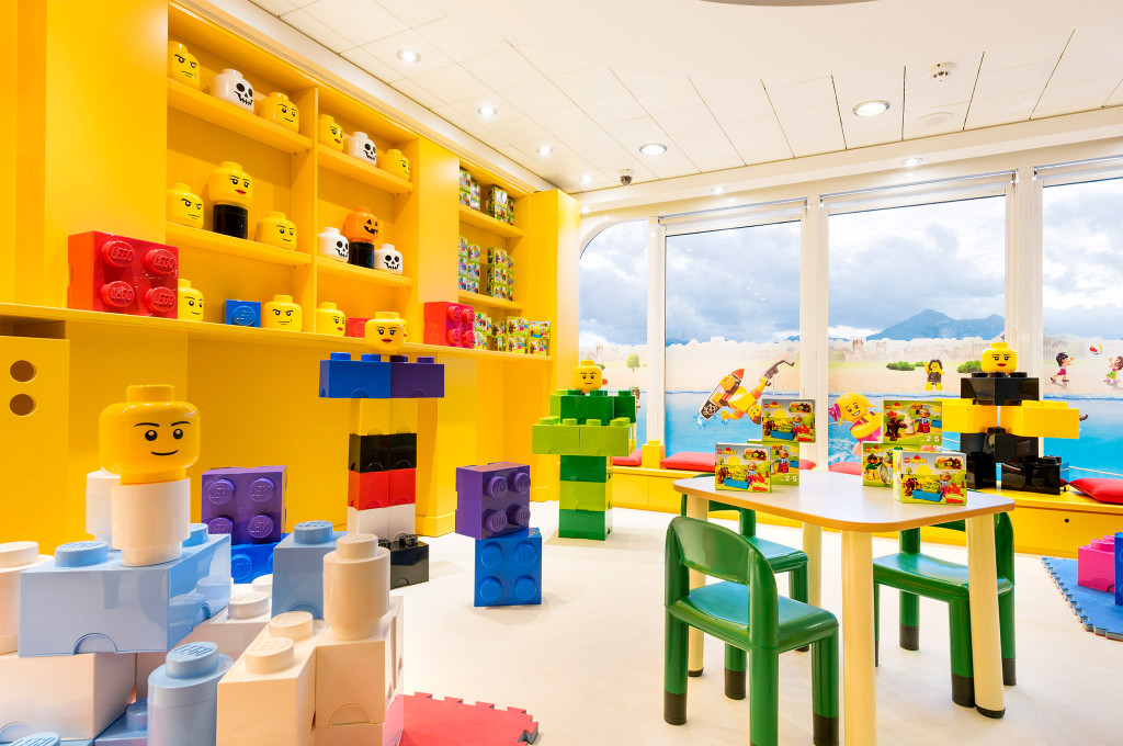 Farbenfroher Kinderspielbereich mit riesigen Bausteinen, Spielfiguren und Spieltischen auf einem Kreuzfahrtschiff