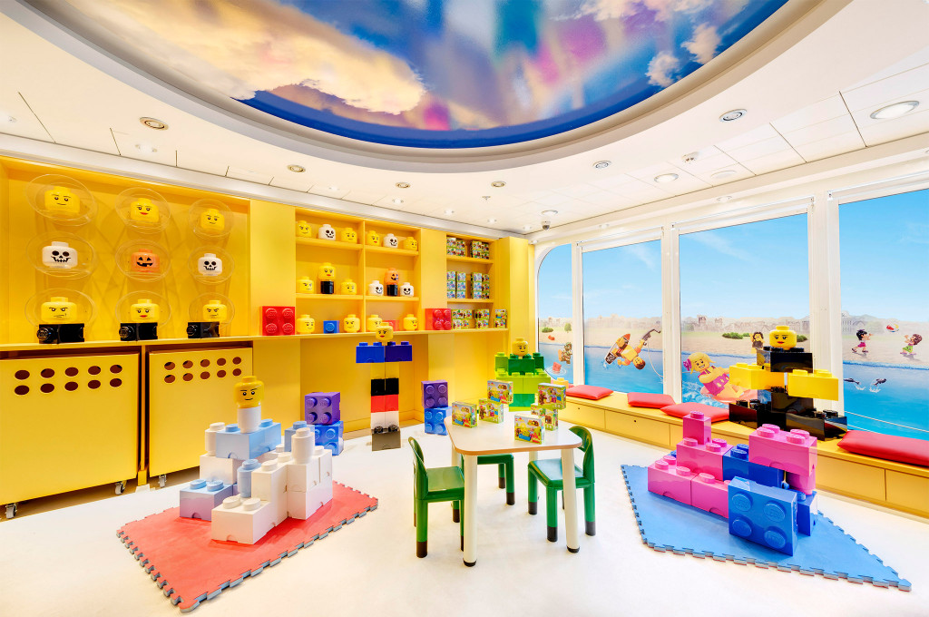 LEGO-Spielzimmer für Kinder auf einem Kreuzfahrtschiff mit riesigen Bausteinen und LEGO-Minifiguren-Köpfen an der Wand