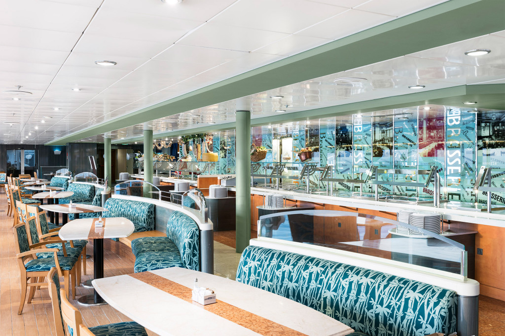 Buffetrestaurant mit gemusterter Polsterbank und beleuchteter Bufetttheke auf einem Kreuzfahrtschiff
