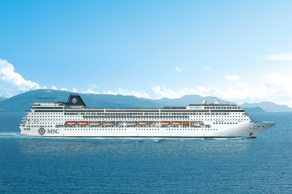 MSC Armonia auf dem Meer vor bewaldeter Küste, Seitenansicht von Steuerbord