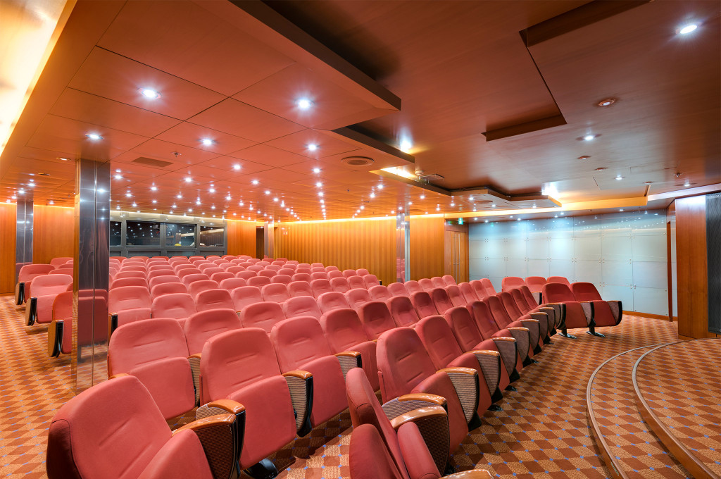 Konferenz- und Kinoraum mit Reihen roter Sessel auf einem Kreuzfahrtschiff