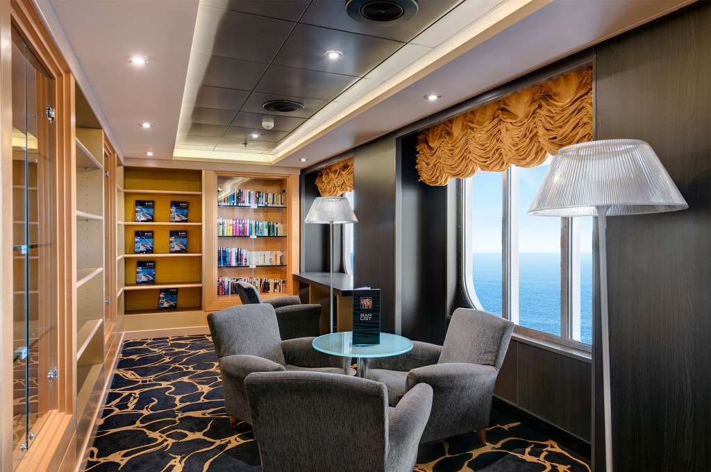 Gemütliche Bibliothekslounge mit Bücherregalen, Sesseln und Meeresblick auf einem Kreuzfahrtschiff