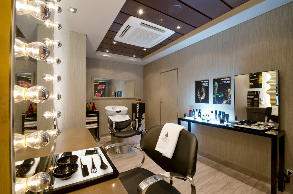 Friseursalon mit beleuchtetem Theaterspiegel, Frisierstation, Haarwaschbecken und Produktauslage an Bord