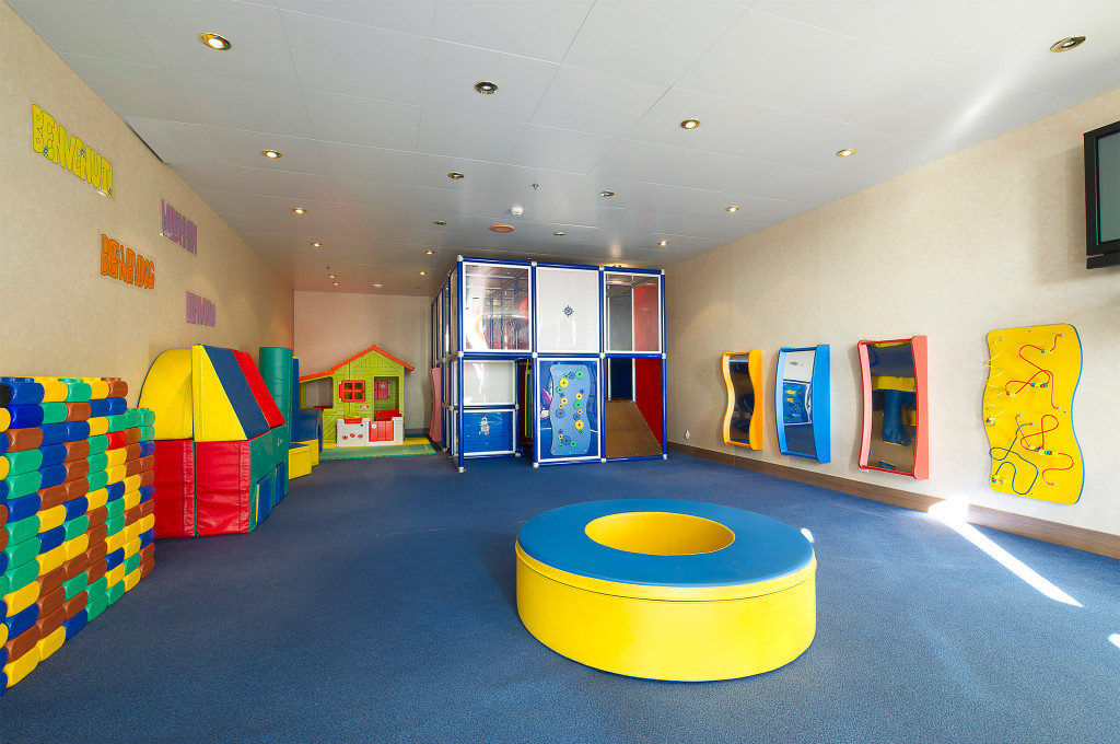 Kinderclub auf einem Kreuzfahrtschiff mit bunten Schaumstoffbausteinen, Kletterstruktur, Spielhaus und wandmontierten Aktivitätsspielen