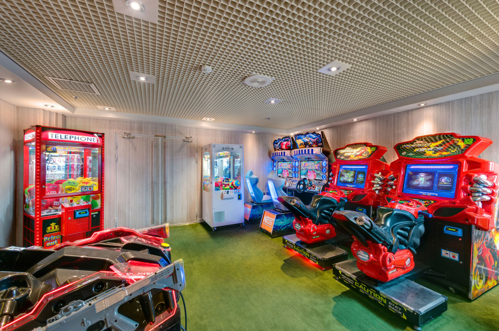 Spielhalle der MSC Sinfonia mit Arcade-Fahrsimulatoren, Greifautomaten und bunten Spielautomaten