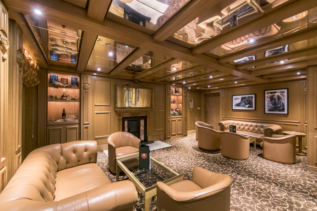 Elegante Zigarrenlounge mit Chesterfield-Ledersesseln, Kamin und holzvertäfelten Wänden auf der MSC Sinfonia