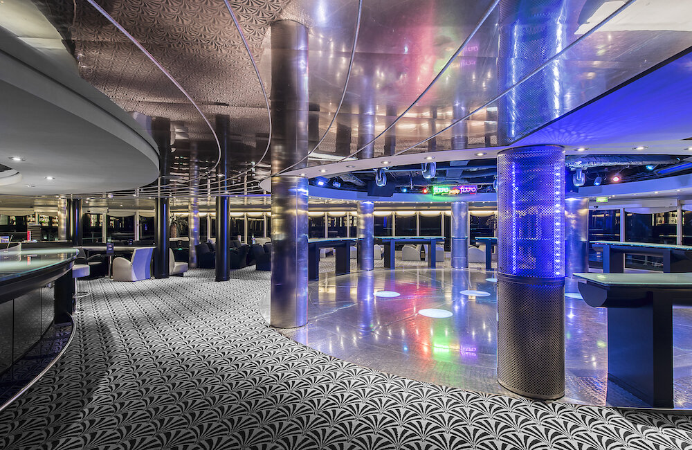 Diskothek Pasha Club der MSC Sinfonia mit beleuchtetem Tanzparkett, Chromsäulen und gemustertem Teppich