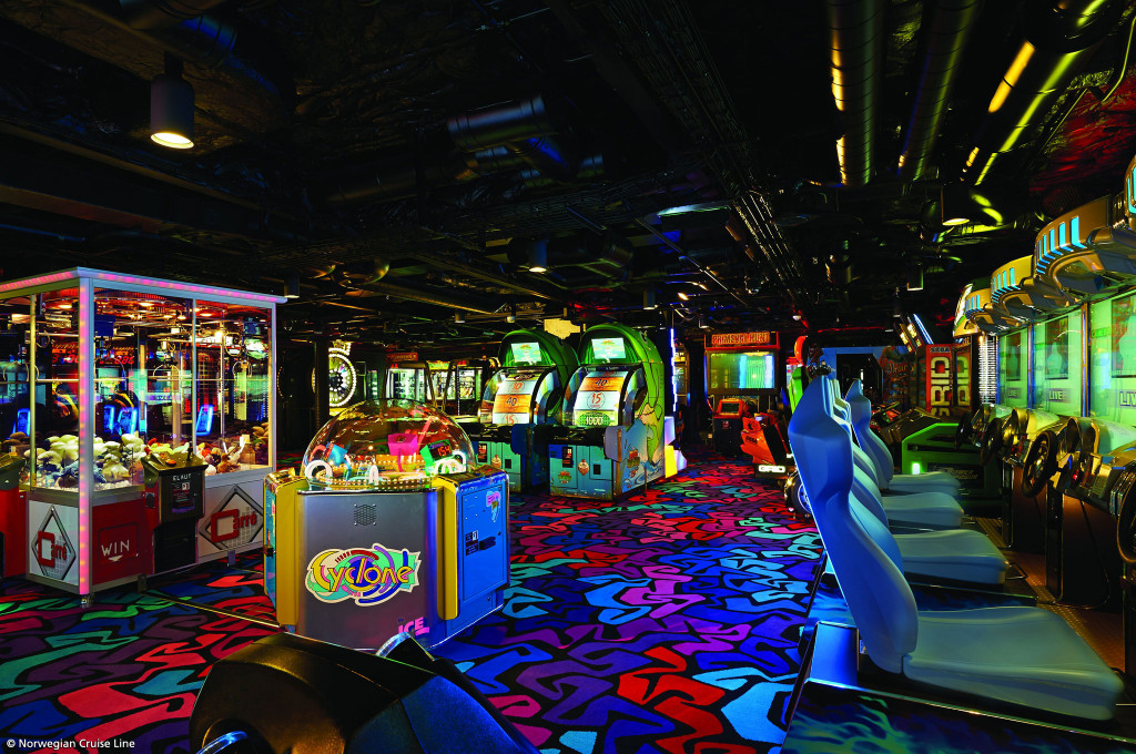 Spielhalle mit zahlreichen Arcade-Automaten und Rennspielen für Jugendliche an Bord eines Hochseekreuzfahrtschiffes.