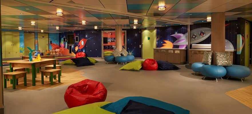Kinderclub auf der Norwegian Getaway mit bunten Sitzsäcken, Spieltischen und Weltraum-Wandgemälde