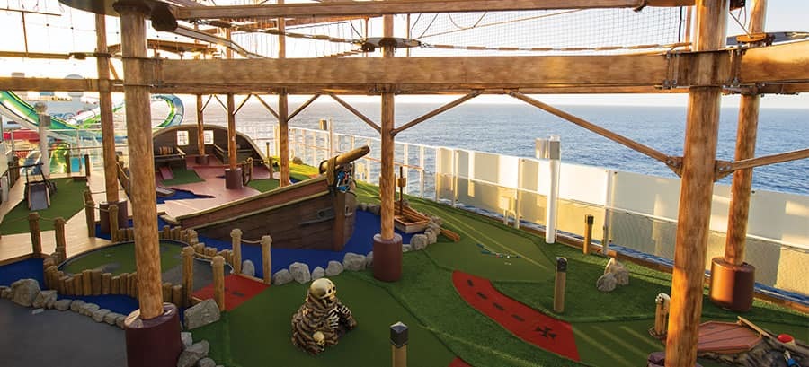 Piraten-Minigolfanlage auf einem Kreuzfahrtschiff mit Totenkopfdekor, Piratenschiff-Element und Klettergerüst über dem Deck