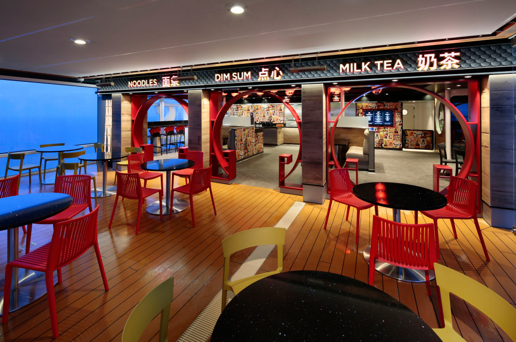 Moderne Kaffeebar mit roten Sesseln und Meeresblick auf Hochseekreuzfahrtschiff