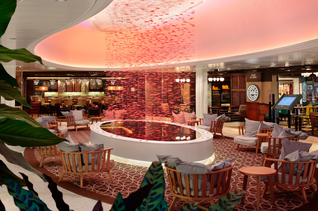 Moderne Lounge mit roten Sesseln und beleuchteter Deckeninstallation auf Hochseeschiff