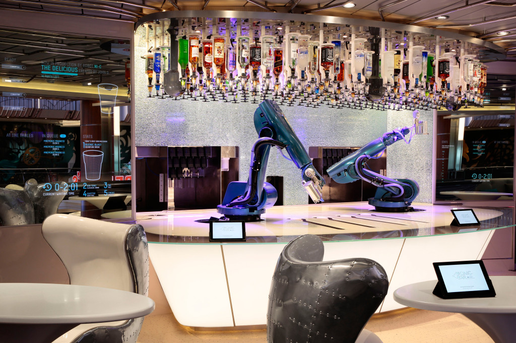 Roboterarme mixen Cocktails an einer futuristischen Bar mit Flaschenwand und Tablet-Bestellstationen an Bord eines Kreuzfahrtschiffs.