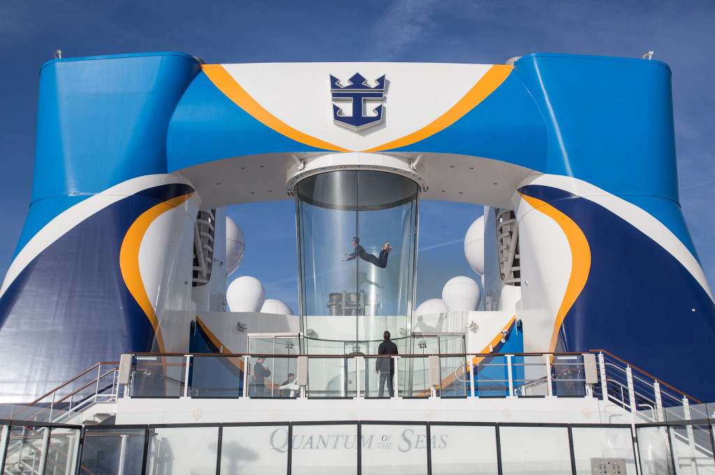 Glaszylinder mit Indoor-Skydiving-Windkanal am Heck eines Kreuzfahrtschiffs, eine Person schwebt im Luftstrom.