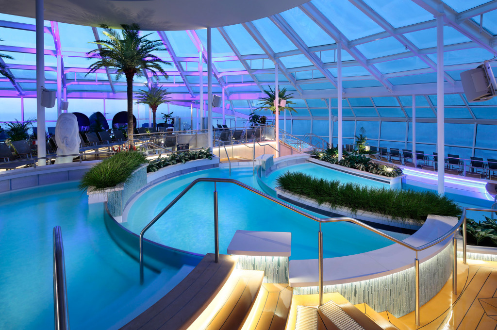 Überdachtes Solarium mit beheiztem Innenpool, Whirlpools und Palmen unter einem Glasdach an Bord der Quantum of the Seas.