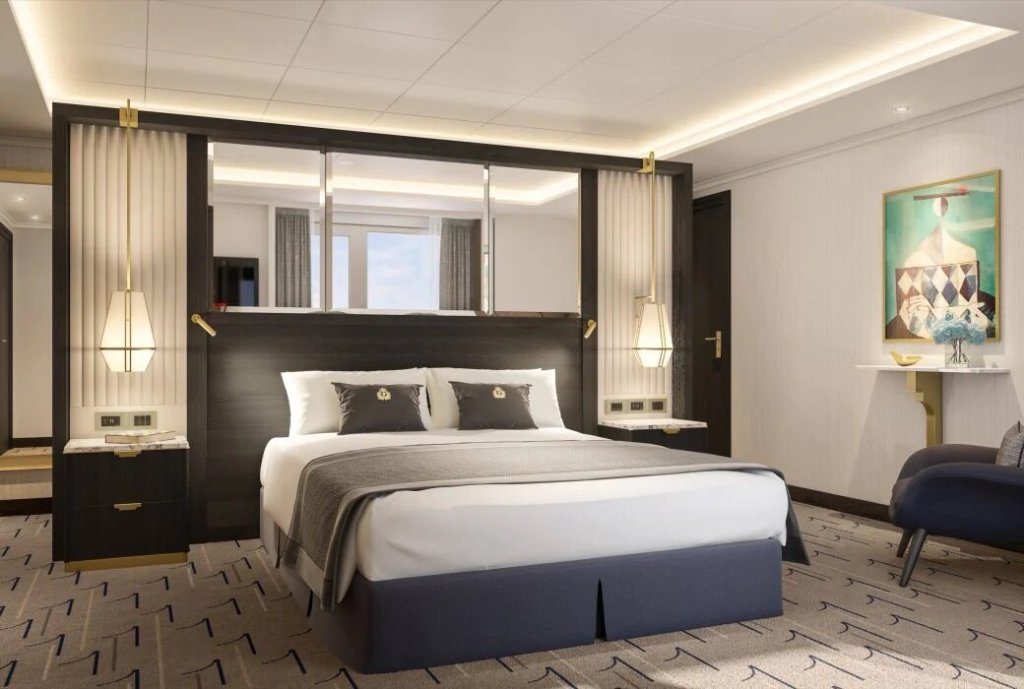 Schlafzimmer der Grand Suite auf der Queen Anne mit Kingsize-Bett, dunklen Holzpaneelen und dekorativen Spiegelelementen.