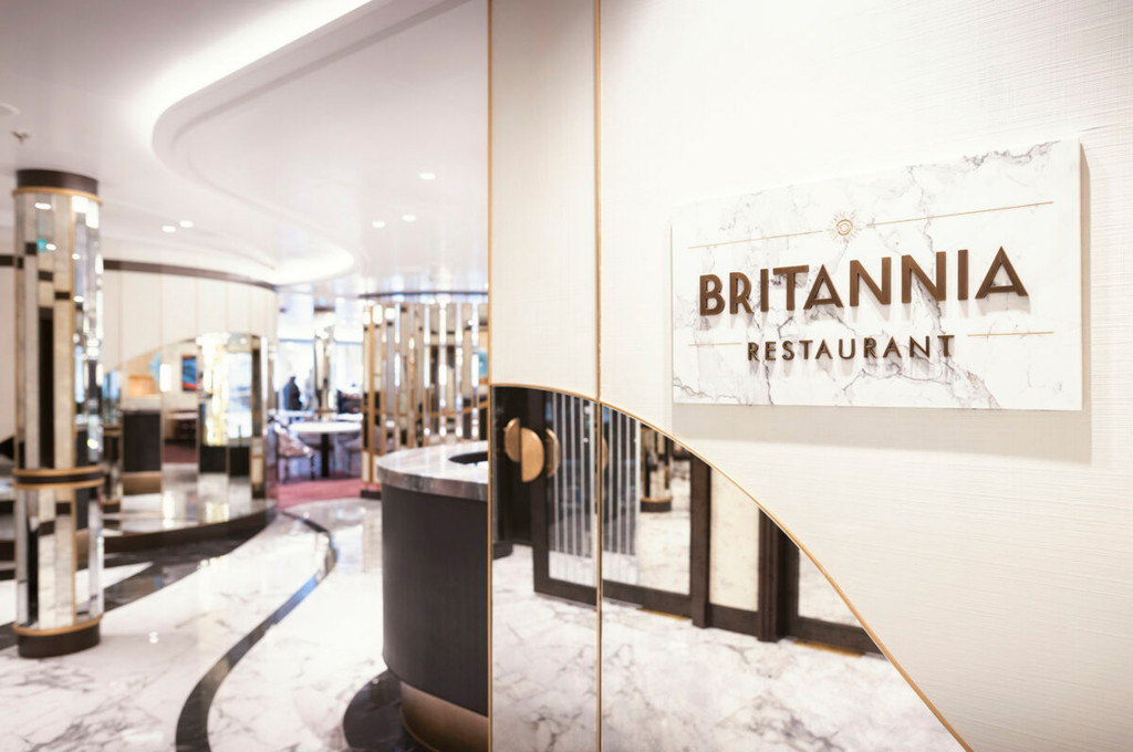 Eingangsbereich des Britannia Restaurants mit Marmorschild, Marmorbodenbelag und goldenem Empfangstresen