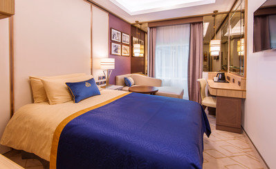 Außenkabine zur Alleinbenutzung auf der Queen Mary 2 mit Doppelbett, Schreibtisch und Fenster.