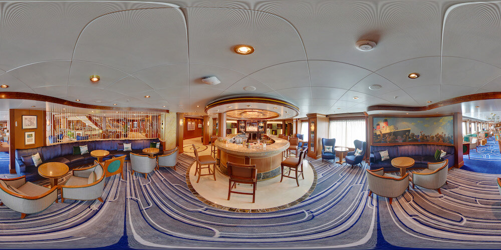 360-Grad-Panoramabild der Chart Room Bar auf der Queen Victoria mit rundem Tresen und eleganten Sitzbereichen.
