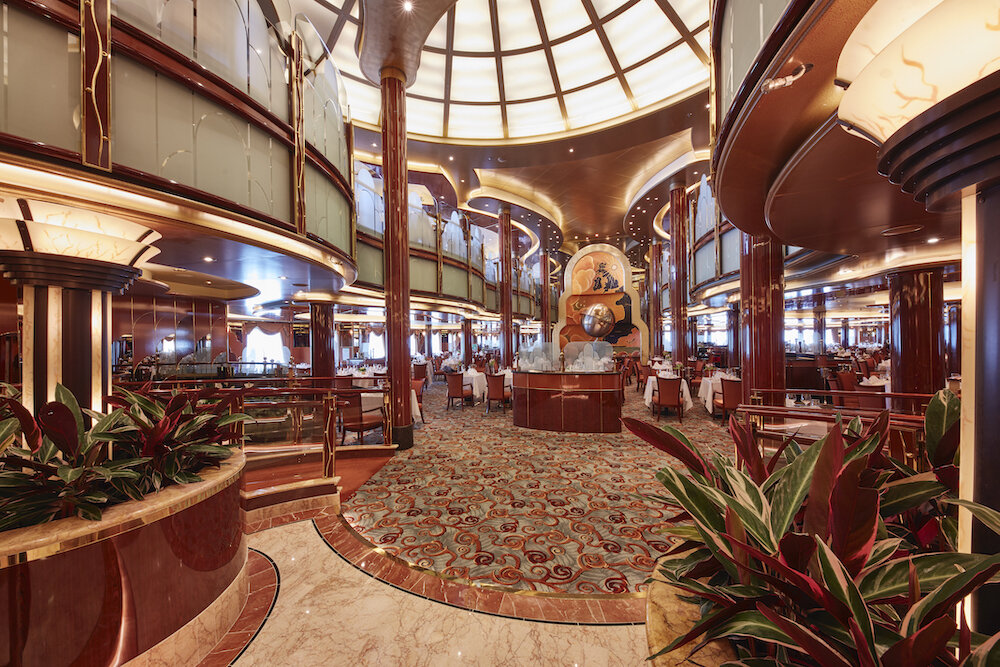 Britannia Restaurant Atrium mit marmoriertem Boden und elegantem Interieur auf einer Hochseekreuzfahrt.