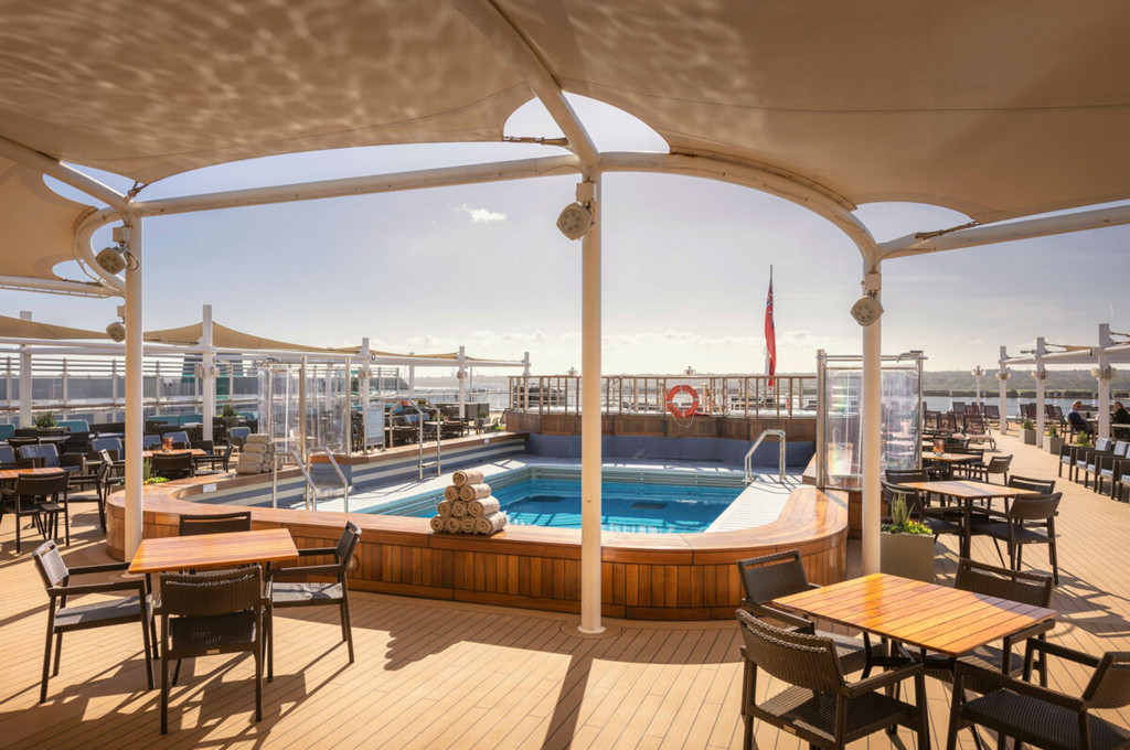 Lido-Pooldeck der Queen Victoria mit kleinem Pool, Rattanmöbeln und großem Sonnensegel
