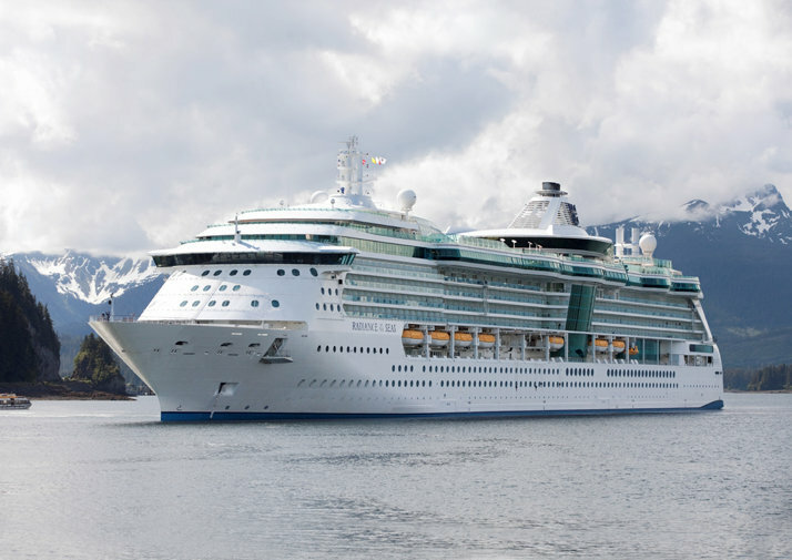 Radiance of the Seas bei der Fahrt über das Meer mit bergiger Küste im Hintergrund.
