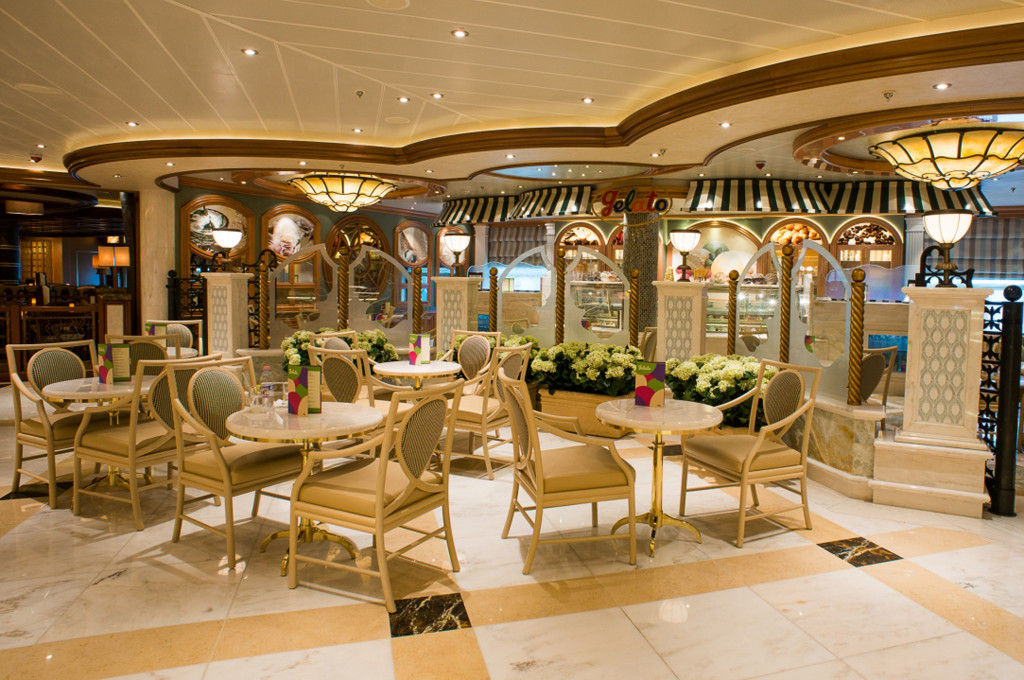 Das Gelato Eiscafé mit eleganter Bestuhlung, Blumendekoration und Deckenleuchten auf der Royal Princess.
