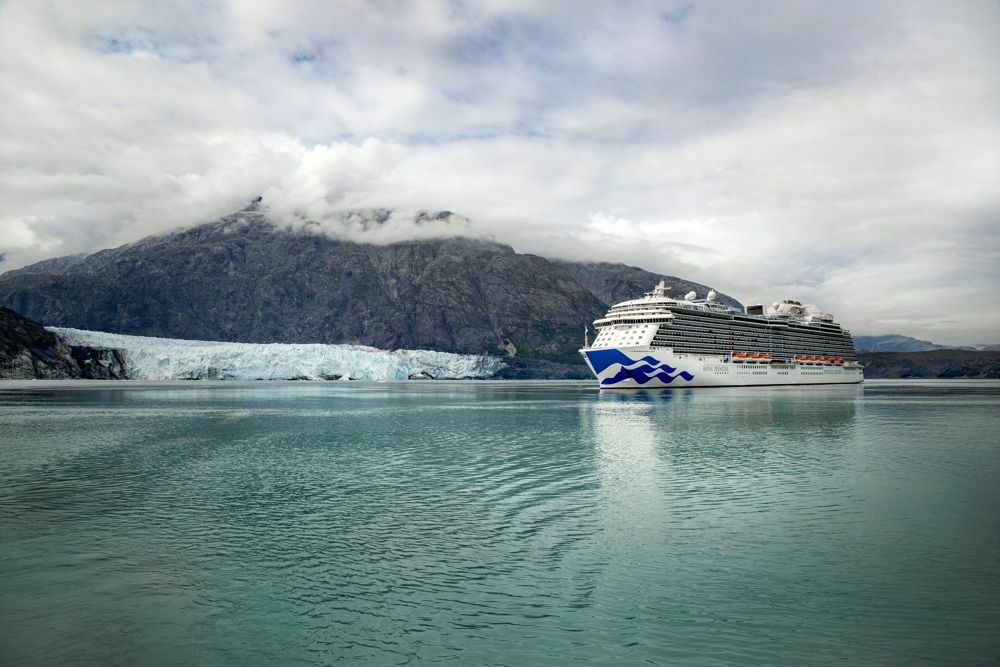 Royal Princess vor einem Gletscher in Alaska mit schneebedeckten Bergen und ruhigem Wasser