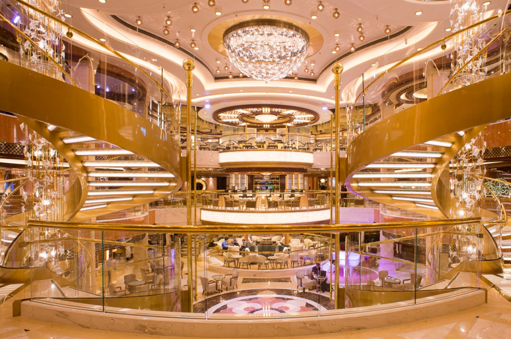 Das Atrium mit mehreren Decks, Kronleuchtern und eleganten Treppen auf der Royal Princess.