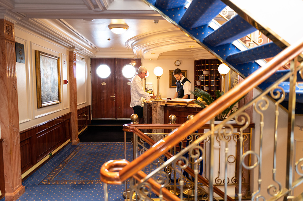 Elegante Rezeptionshalle mit klassischer Holzausstattung und Treppenhaus auf der Sea Cloud II