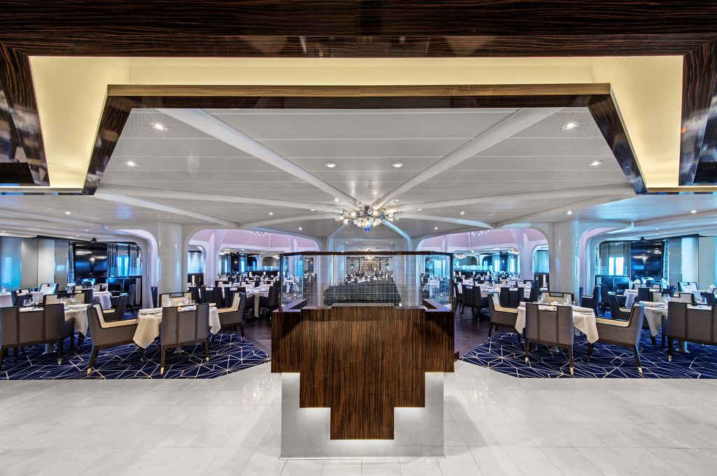 Elegantes Hauptrestaurant mit weißen Tischdecken, modernem Design und panoramischem Meeresblick auf der Seabourn Ovation.