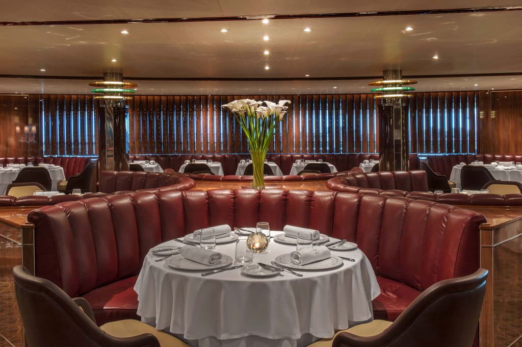 The Grill by Thomas Keller auf der Seabourn Ovation mit weinroten Lederbänken, weißen Tischdecken und elegantem Ambiente.