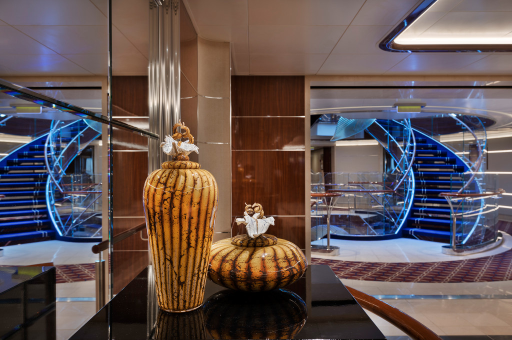Beeindruckendes Schiffsatrium mit modernem Design, goldenen Kunstskulpturen und eleganter Beleuchtung auf der Seabourn Ovation.