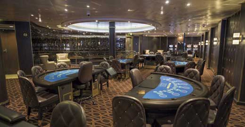 Casino der Seven Seas Mariner mit Spieltischen, dunklen Ledersesseln und Spielautomaten im Hintergrund