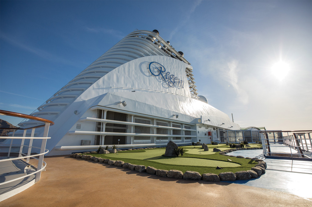 Sports Deck mit Minigolfanlage und gepflegtem Putting Green vor dem markanten Schornstein der Seven Seas Mariner bei Sonnenschein.