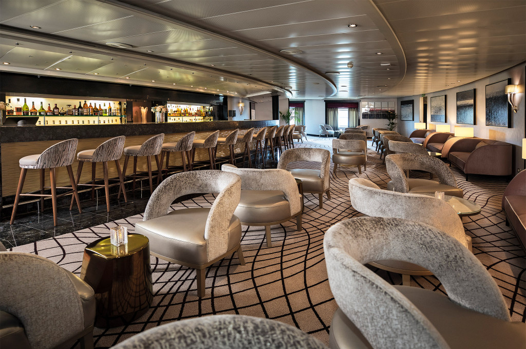 Stars Lounge mit langer Bar, samtenen Barhockern und gemütlichen Sitzecken an Bord der Seven Seas Navigator.