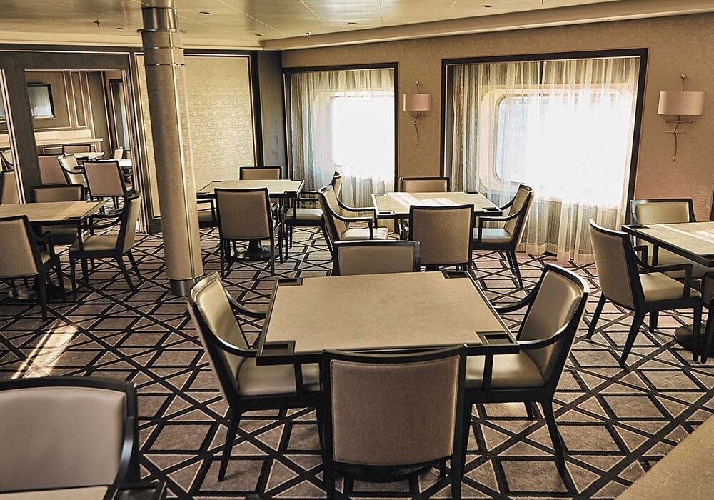 Card Room mit Sitztischen und eleganter Ausstattung auf Luxuskreuzfahrtschiff
