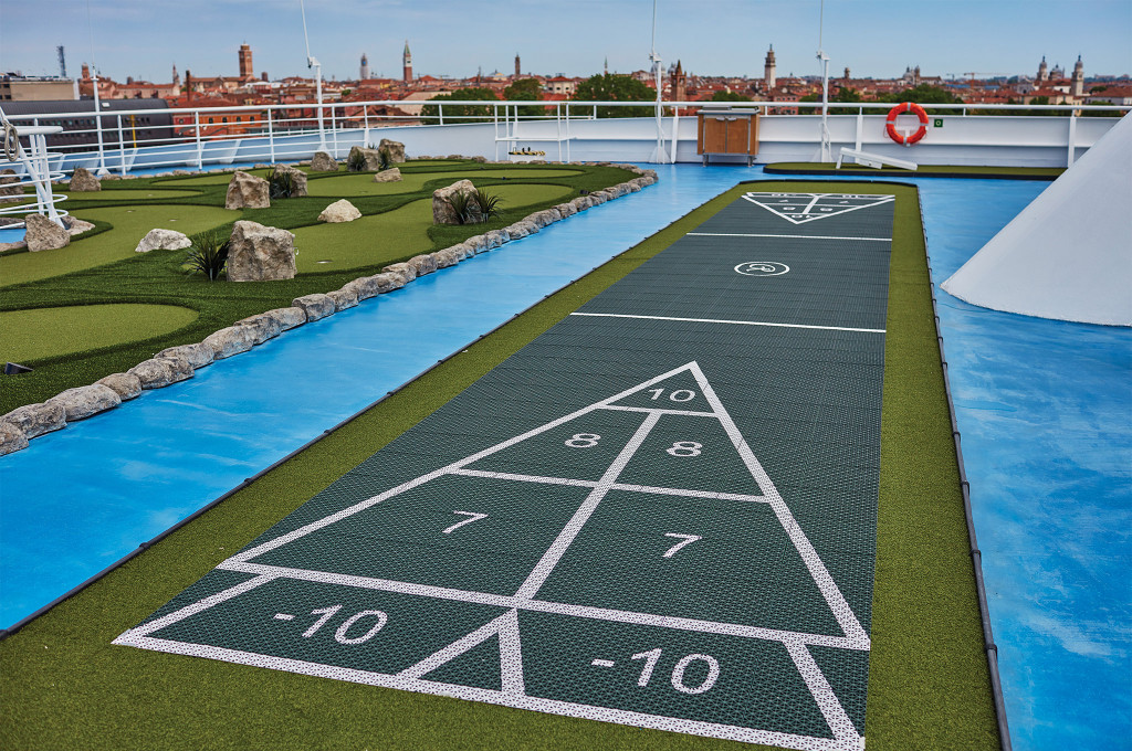 Sport Deck mit Shuffleboard-Feld und Putting Green vor der historischen Skyline von Venedig an Bord der Seven Seas Navigator.